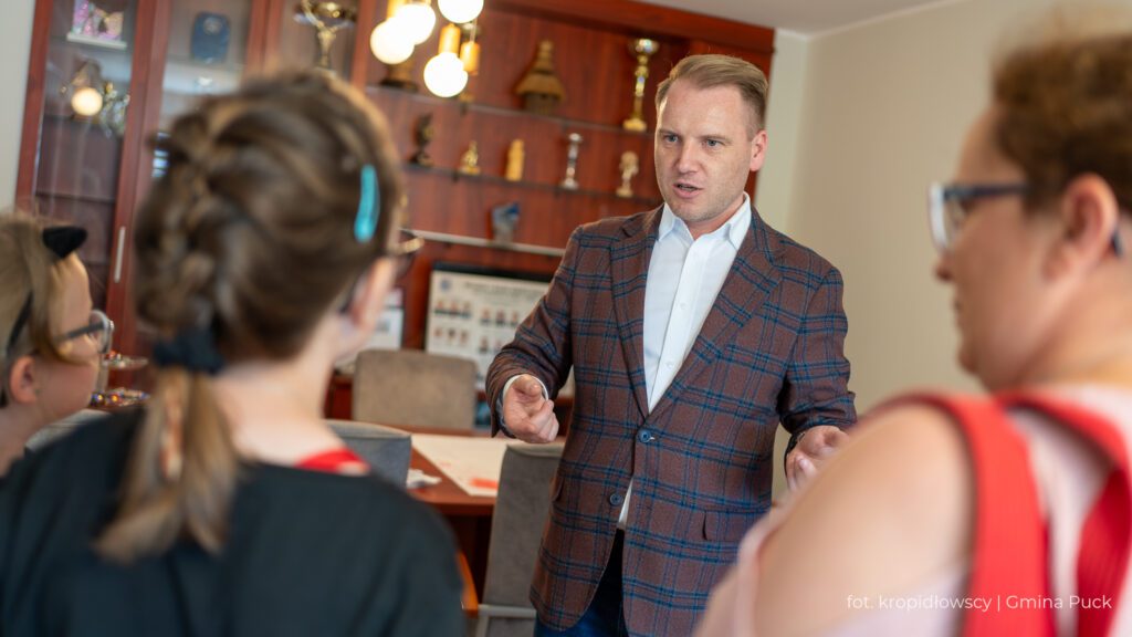 Wójt Gminy Puck rozmawia z grupą dzieci w biurze.