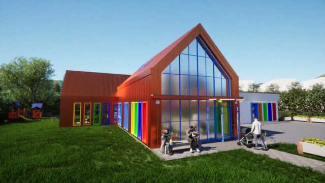 Wizualizacja nowego budynku żłobka w Rekowie Górnym z kolorowymi oknami i dużymi przeszkleniami. Przed wejściem osoby dorosłe z dziećmi, obok plac zabaw i trawnik.