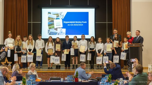 Laureaci stypendiów Wójta Gminy Puck dla klas IV i V za rok 2023/2024 pozują do pamiątkowego zdjęcia wraz z przedstawicielami władz Gminy Puck.
